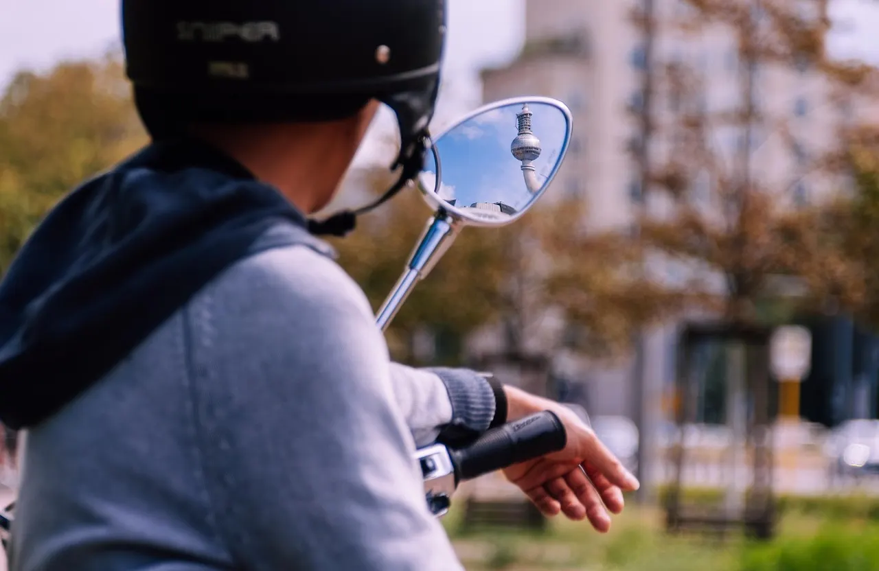 Conducteur casqué de dos sur un deux-roues, en ville